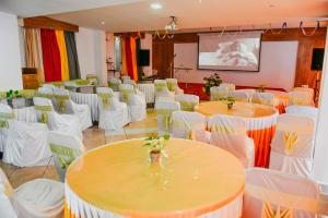 a banquet hall with white tables and white chairs at Chill Berg Resort - Bodimettu in Theni
