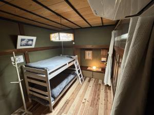 a bedroom with a bunk bed in a room at ゲストハウス あめりか和 in Namerikawa