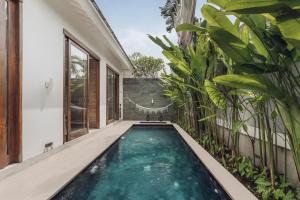 an infinity pool in a house with plants at Astera Villa Seminyak by Ini Vie Hospitality in Seminyak