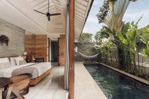 a bedroom with a bed next to a swimming pool at Astera Villa Seminyak by Ini Vie Hospitality in Seminyak +22 photos