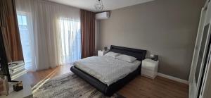 a bedroom with a bed with a black headboard at Anca House in Baia Mare