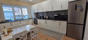 a kitchen with white cabinets and a refrigerator at Anca House in Baia Mare