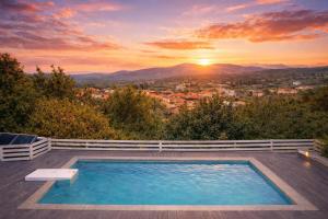 a swimming pool on the deck of a house with a sunset at Casa Campanario Villa - Charming Nature Villa with Pool in a Picturesque Village By Villa Mana Gers in Agios Leon