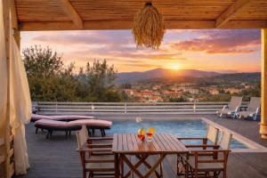 a patio with a pool and a view of a sunset at Casa Campanario Villa - Charming Nature Villa with Pool in a Picturesque Village By Villa Mana Gers in Agios Leon