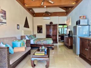 a living room with a couch and a table at Sibaja Palms Sunset Beach Luxury Apartments in Taling Ngam Beach