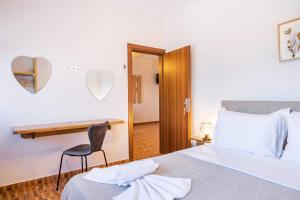 a bedroom with a bed and a desk and a chair at Enalia Suites in Amoopi