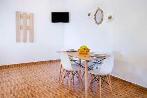 a dining room table with chairs and a bowl of fruit on it at Enalia Suites in Amoopi