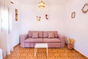 a purple couch in a living room with a table at Enalia Suites in Amoopi