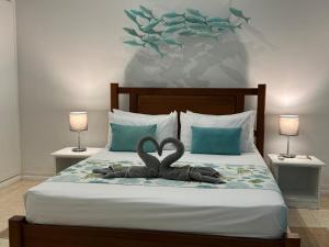 a bed with a statue of two swans on it at Korail Bleu in Rodrigues Island