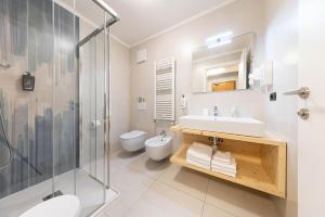 a bathroom with a sink and a toilet and a shower at Family Hotel La Perla in Fiera di Primiero +85 photos