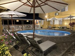 a pool with chairs and umbrellas in a hotel at Korail Bleu in Rodrigues Island +16 photos