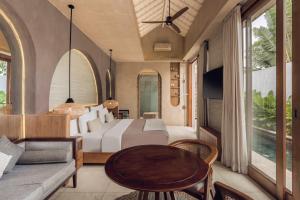 a bedroom with a bed and a table at Astera Villa Seminyak by Ini Vie Hospitality in Seminyak
