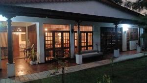 a house with a porch with a couch in it at Country Homes Srilanka in Mount Lavinia +12 photos