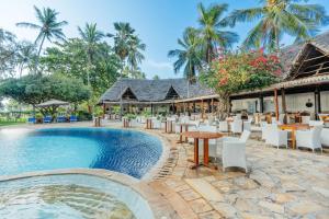 a resort with a pool and tables and chairs at Bluebay Beach Resort & Spa in Kiwengwa