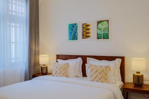 a bedroom with a large bed with two lamps at Eklektik in Colombo