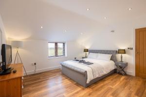 a bedroom with a bed and a flat screen tv at Jenny's Barn - Sleeping 9, Dog friendly in Staveley