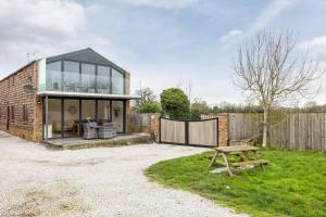 a brick house with glass windows and a picnic table at Jenny's Barn - Sleeping 9, Dog friendly in Staveley