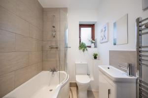 a bathroom with a tub and a toilet and a sink at Jenny's Barn - Sleeping 9, Dog friendly in Staveley +26 photos