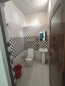 a bathroom with a toilet and a sink and a mirror at Harigarh Inn in Alīgarh +36 photos