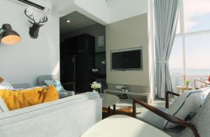 a living room with a couch and a tv at Maritime Full Seaview Duplex Suites in George Town