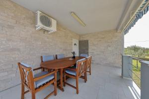 a dining room with a wooden table and chairs at Eda in Vrsi