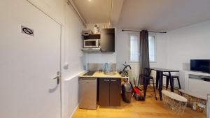 a small kitchen with a sink and a table at chaleureux studio Maillart centre ville in Le Havre