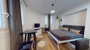 a small room with a bed and a desk at chaleureux studio Maillart centre ville in Le Havre