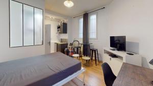 a bedroom with a bed and a table and chairs at chaleureux studio Maillart centre ville in Le Havre