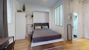 a bedroom with a bed in the middle of a room at chaleureux studio Maillart centre ville in Le Havre