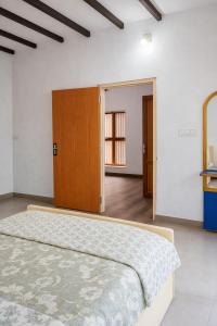 a bedroom with a bed and a wooden cabinet at MAK Mansion in Kotikulam