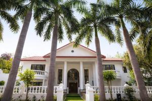 a house with palm trees in front of it at Tivoli Bijwasan in Jāmb