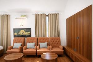 a living room with two chairs and a couch at Tivoli Bijwasan in Jāmb