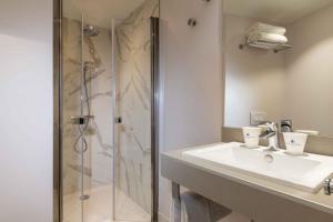 a bathroom with a sink and a shower at Queen Mary Opera in Paris +44 photos
