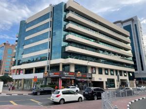 a large building with cars parked in front of it at Deira Guest house by PHM in Dubai