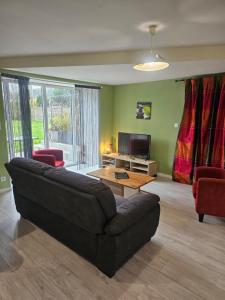 a living room with a couch and a television at gîte Brocéliande - Harmonie et tranquillité près de la mer in Theix
