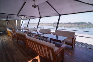 a restaurant on a boat with tables and chairs at Riviera Resort and Hotel in Durg