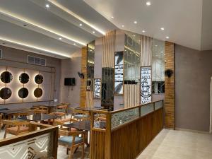 a restaurant with wooden tables and wooden chairs at Riviera Resort and Hotel in Durg