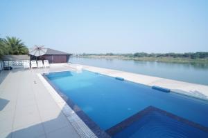 a swimming pool on the banks of a river at Riviera Resort and Hotel in Durg