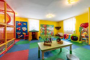 a colorful room with a play room with a table at Family Hotel La Perla in Fiera di Primiero