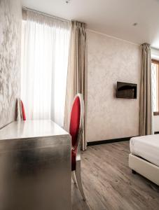 um quarto de hotel com uma secretária e uma cama em Arena Easy Suites Guesthouse em Verona