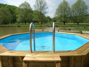 a swimming pool with two metal bars on a wooden deck at Luxurious Holiday Home in Delain with bubble bath in Delain