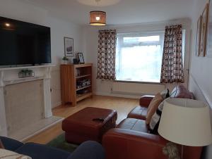 a living room with a couch and a television at 3BR House with garden near Bicester Village in Bicester