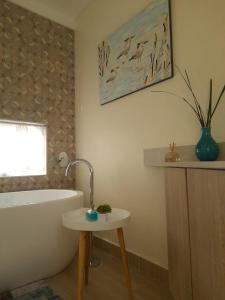 a bathroom with a tub and a table and a sink at Deja Vu Cottage in Sedgefield +20 photos