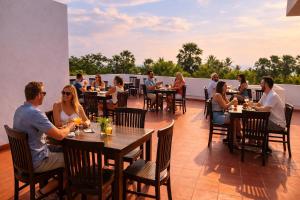 a group of people sitting at tables on a patio at Pearl Diamond Resort in Trincomalee
