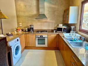 a kitchen with a sink and a washing machine at Sibaja Palms Sunset Beach Luxury Villa in Taling Ngam Beach