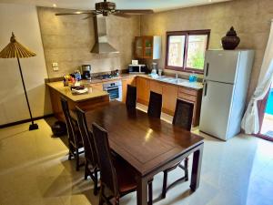 a kitchen with a wooden table and a refrigerator at Sibaja Palms Sunset Beach Luxury Villa in Taling Ngam Beach