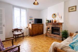 a living room with a fireplace and a tv at Maison entière pour 4 personnes avec parking proche centre ville in Saint-Sulpice-sur-Risle