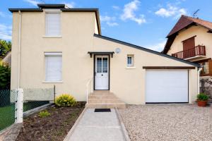 a house with two white garage doors at Maison entière pour 4 personnes avec parking proche centre ville in Saint-Sulpice-sur-Risle
