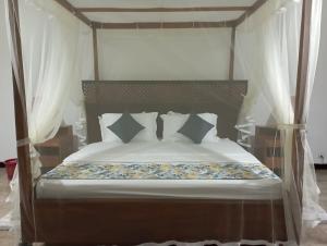 a bedroom with a bed with white sheets and pillows at Country Homes Srilanka in Mount Lavinia