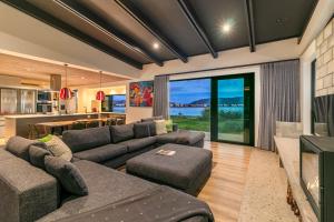 a living room with a large couch and a kitchen at Knysna Tsukamori in Knysna